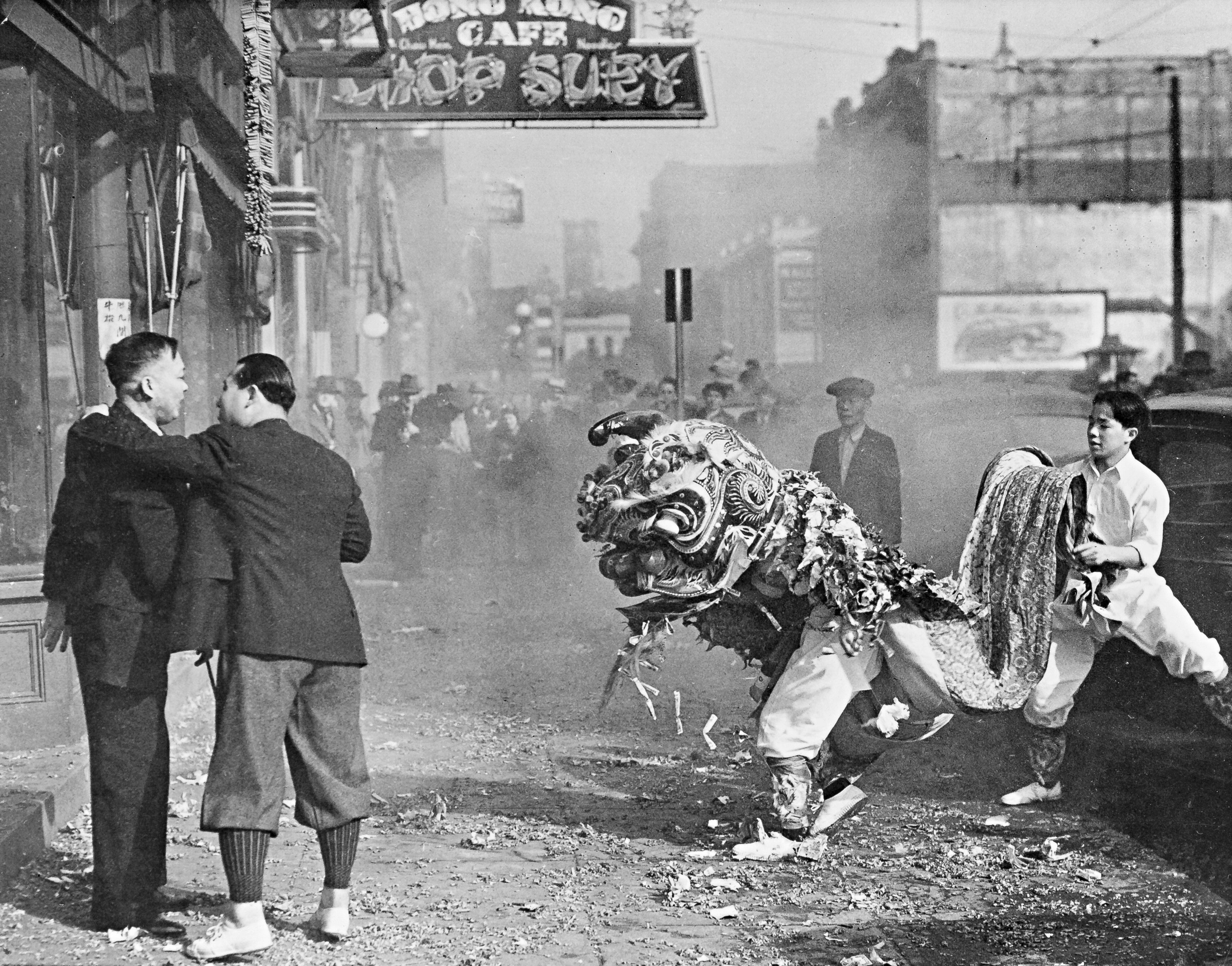 Lion dancers and men in suits on a Portland street in the 1920s