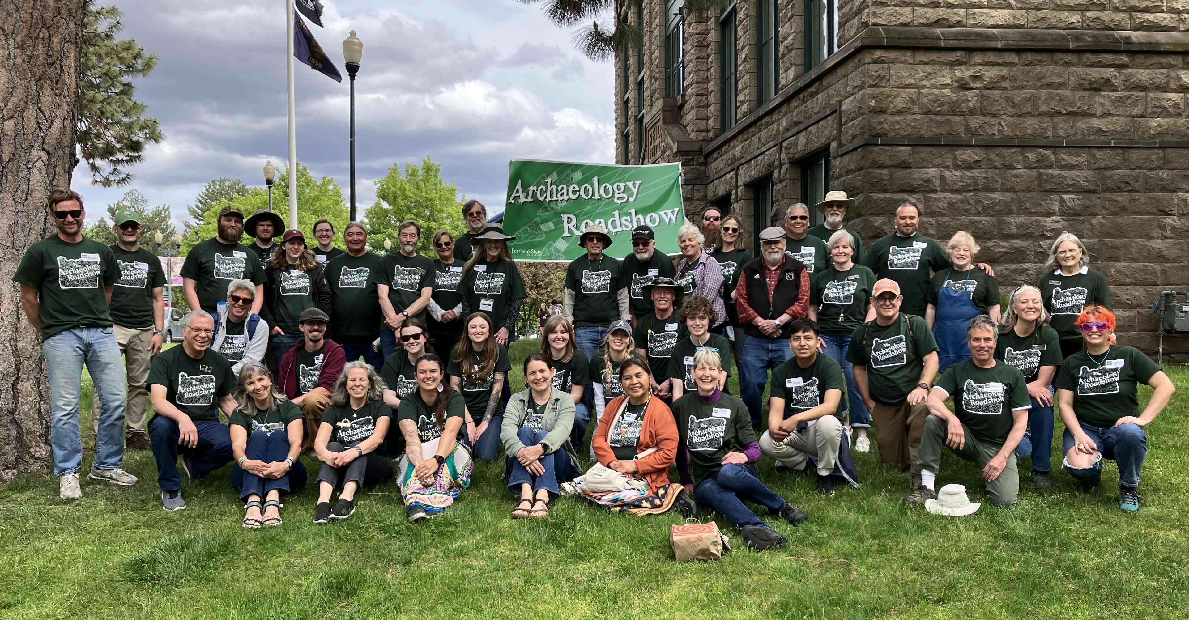 Group photo from the Archaeology Roadshow. About 55 people in matching tee shirts.