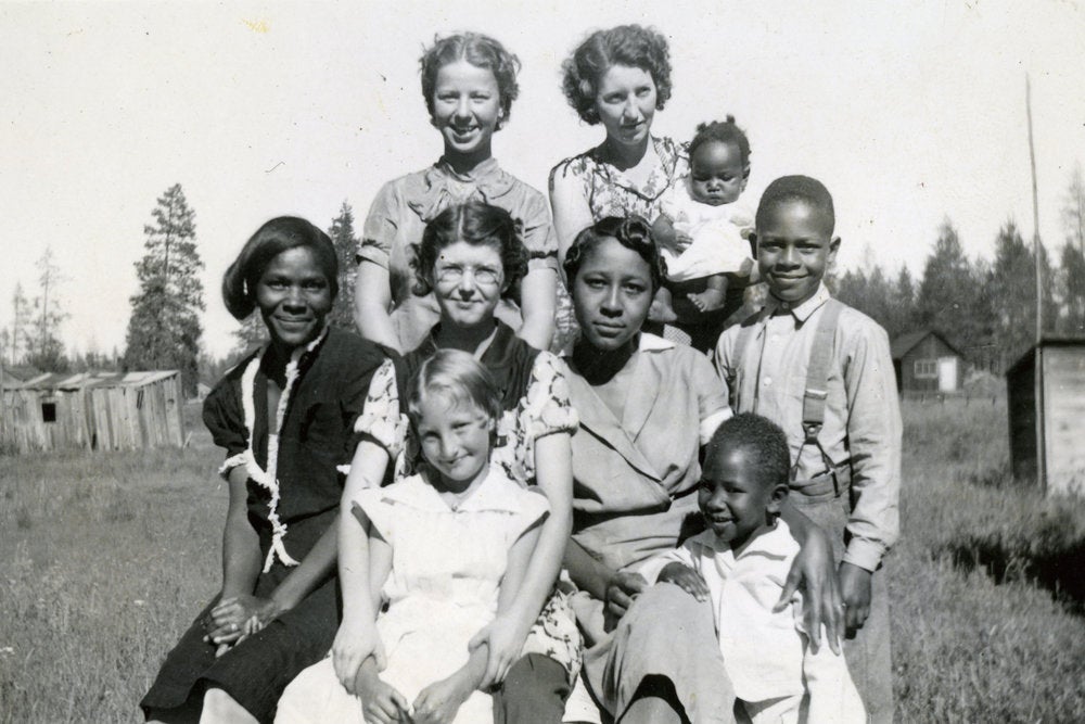 Multiracial families in the Oregon timber industry. Several women, both Black and white, pose with several children, both Black and white.