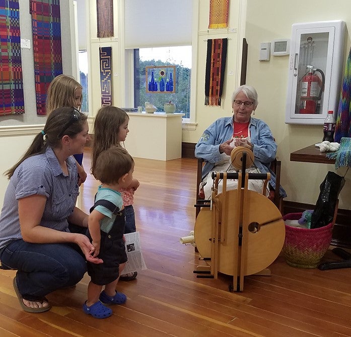 Carol Etchemendy demonstrates spinning wool for over 250 walk-throughs during First Friday.