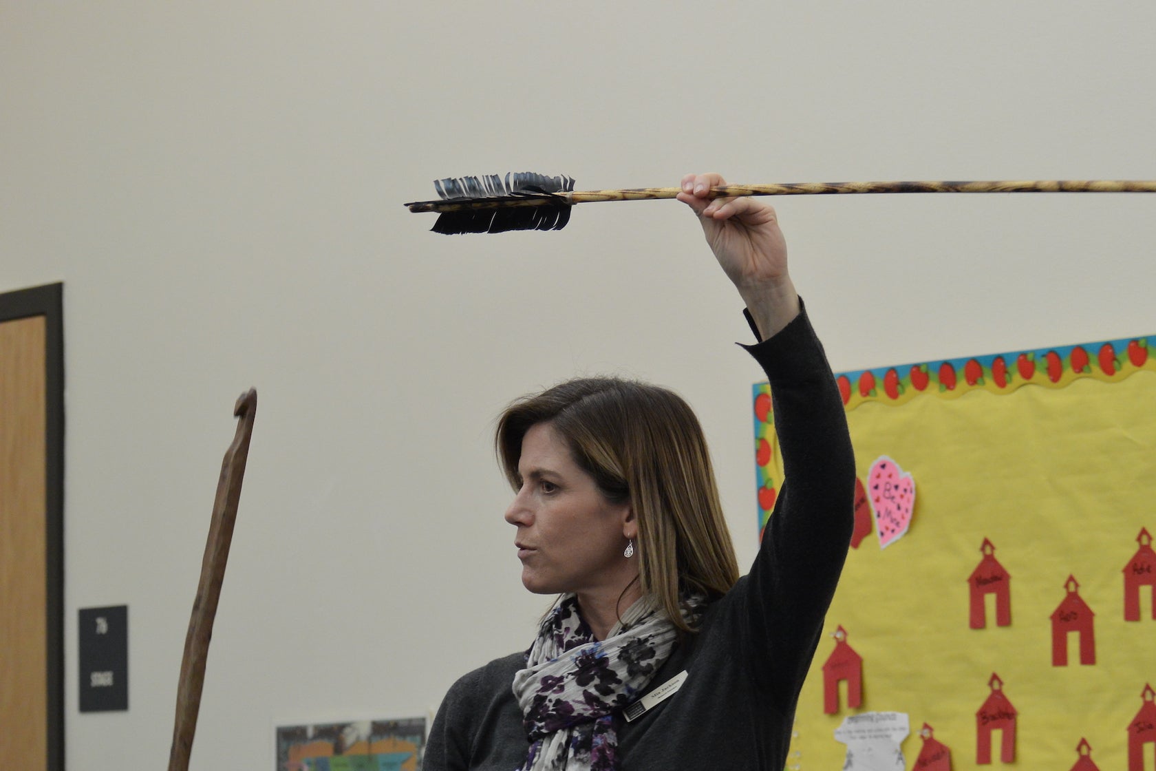 Museum educator holds up an arrow above her head.jpg