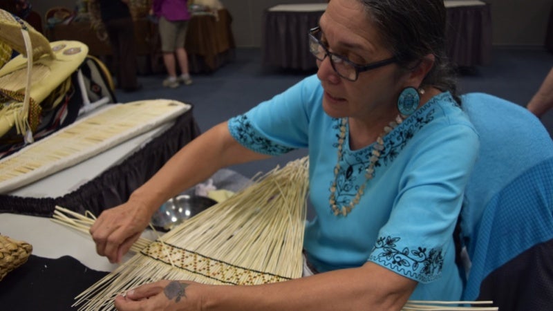 Sara Barton, an Indigenous woman, weaving