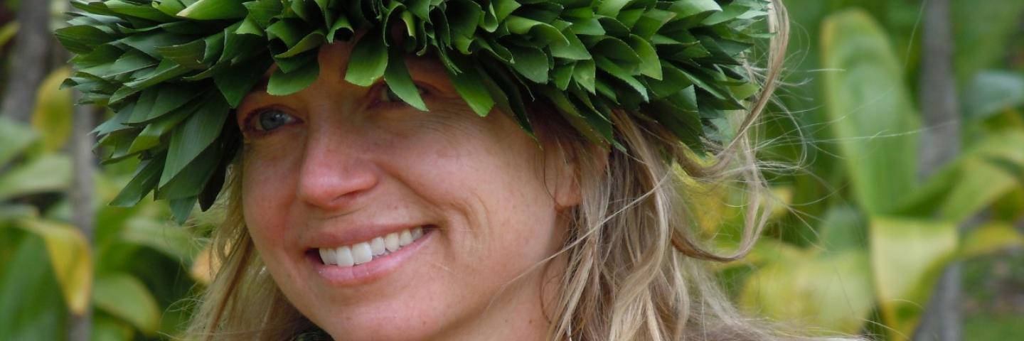 Andrea Luchese is wearing a haku headband and lei around her neck.