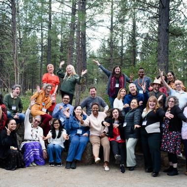 Group poses in a forrest for a group picture.