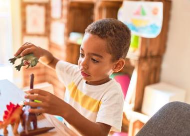 A boy playing with dinosaur toys