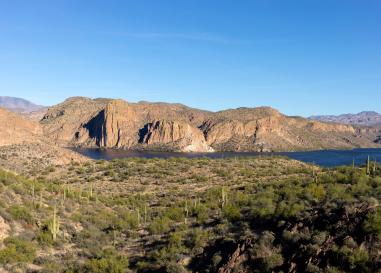 A wide shot of Canyon Lake in Arizona with mesas rising behind it