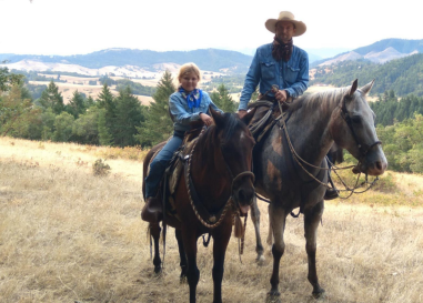 Young girl and father on horseback