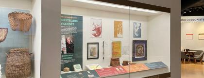 Exhibit case with artwork and Robin Wall Kimmerer photo and book